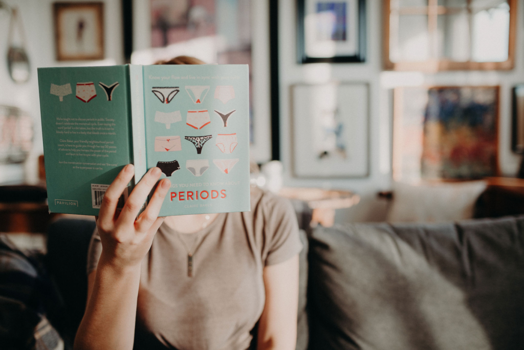 A doula reads a book called PERIODS.