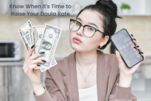 A woman holds a calculator and money. The words: Know When It's Time to Raise Your Doula Rate are written on the photo.