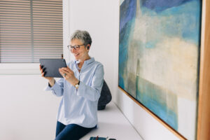 A mature woman looks at a tablet computer.