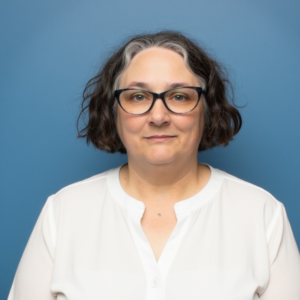 A photo of Robin Elise Weiss in a white shirt on a blue background