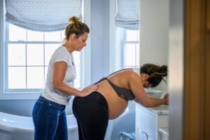 Doula Photography of expecting Pregnant Mother working with Professional Doula at Home