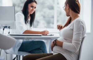 A doula talks to a client across a desk.