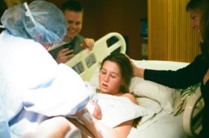 A woman is handed her baby after childbirth.