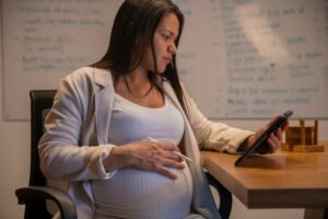 Pregnant woman looks at doula resource list on her tablet.