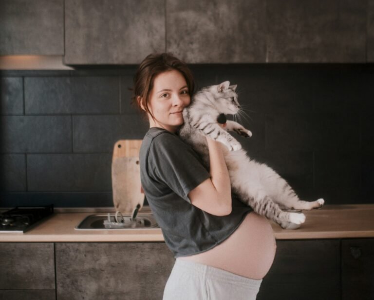 Pregnant woman holding up her cat