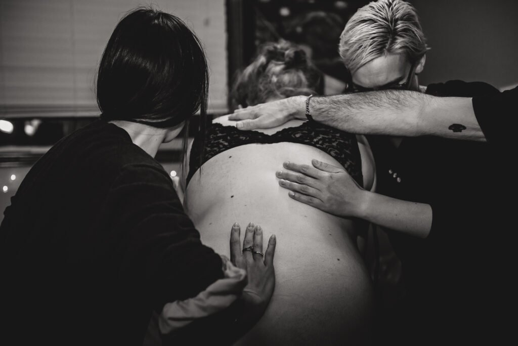 A doula does counter pressure on a laboring woman