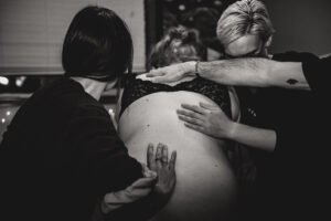 A doula does counter pressure on a laboring woman
