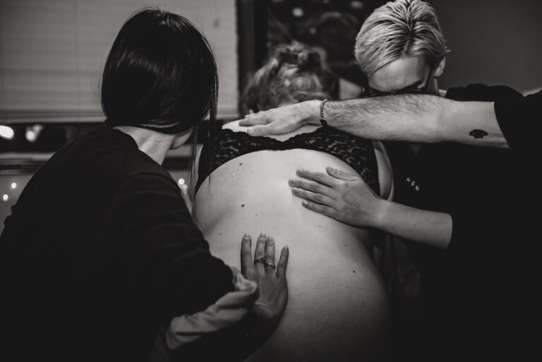 A doula does counter pressure on a laboring woman