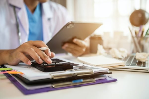 Doctors use a service fee calculator to save money on health insurance, drug cost concepts.